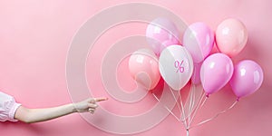 Abstract background with promotional ideas for product prices. Woman hand pointing her finger at a white balloon in pink