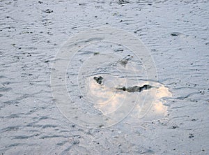 Abstract Background - Puddle of Water with White Sandy Earth with Reflection of Clouds and Sky