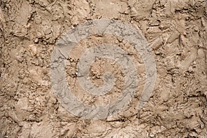 Rough texture, beige preliminary plaster on the wall with irregularities. photo