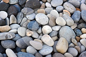 Abstract background with round pebble stones different colors. Stones beach smooth. Top view. Soft focus