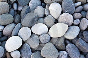Abstract background with round pebble stones. Stones beach smooth. Top view. Summer day