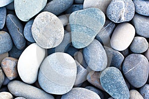 Abstract background with round pebble stones. Stones beach smooth. Top view. Summer day. Close-up