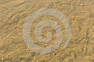 Abstract background of sand ripples under clear water at the beach