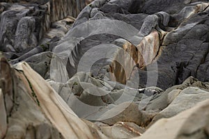An abstract background of sea stones in the coastline, erosion lines of an ancient rock formation.