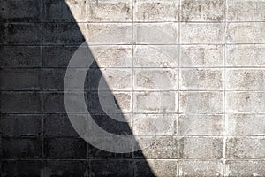Abstract background of shadow and sunlight on the grunge concrete block wall