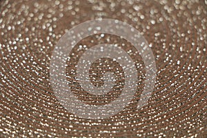 Abstract background of shiny rings of gray, black and beige colors with iridescent glitter