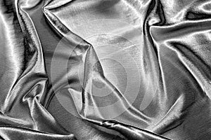 Abstract background with silver silk fabric texture. Luxurious flowing silver textile