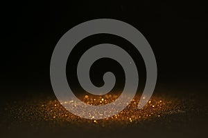 Abstract background of Sprinkle gold dust with glitter lights on black background