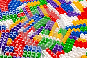 Abstract background texture of colored constructor blocks. Background of colorful plastic part of constructor. Pile of colored toy