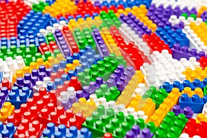 Abstract background texture of colored constructor blocks. Background of colorful plastic part of constructor. Pile of colored toy