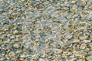 Abstract background texture, Colorful sea stones in water. Wonderful natural background. Clear crystal shallow blue sea