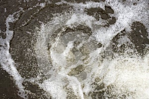 Abstract background. The texture of the foamed surface of the water at the foot of the waterfall.