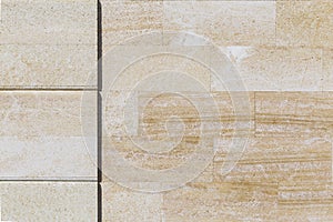 Abstract background and texture of a fragment of a new built stone wall lined with beige tiles with a copy space for writing text