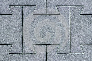 Abstract background texture of rubberized coating in the form of pavers on a dark gray street.