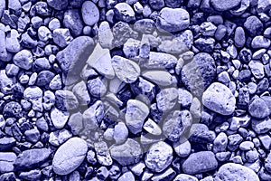 Abstract background texture, sea stones, pebble, top view. photo toned in the color of the year very peri