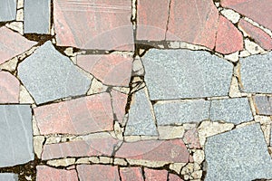 Abstract background with a texture of a stone mosaic. Large gray and pale red granite fragments are chaotically lined. .
