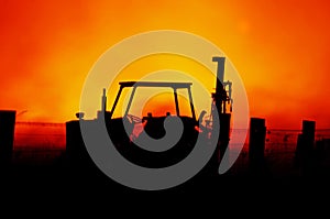 Abstract background tractor & farm fence with blazing Australian bushfire