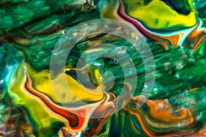 Abstract background of watercolor paints in green, orange and yellow colors.