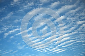 Abstract background of white wavy clouds on a bright blue sky