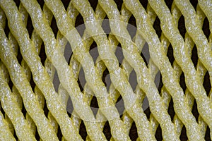 Abstract background of yellow plastic mesh texture for fruit, close up