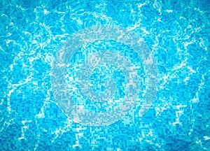 Abstract beautiful blue water in swimming pool. Shining sun reflection, motion of ripple wave. Background of water surface.