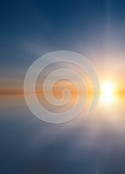 Abstract Beautiful calm sea at sunset with sun and cirrus clouds