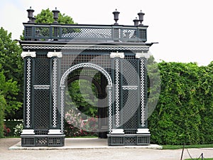 Abstract black garden arbor, flower beds and shorn trees in well