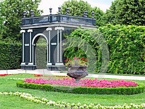 Abstract black garden arbor, flower beds and shorn trees in well-kept park