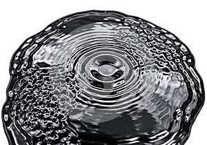 Abstract black liquid surface with ripples and bubbles
