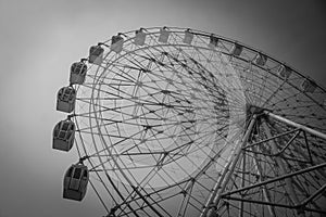 Abstract Black and White image part of colorful ferris wheel with blue sky background.