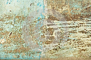 Abstract blue, beige and turquoise background wallpaper texture. Old flaky paint peeling off grungy cracked wall. Cracks, scrapes