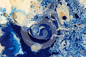 Abstract blue bubble blot and drops horizontal beige background. Marble texture. Acrylic color in water and oil