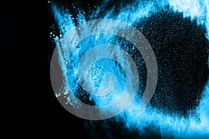 Abstract blue dust explosion on black background