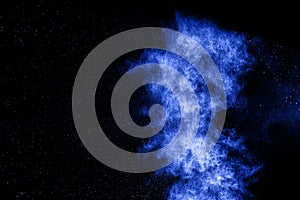 Abstract blue dust explosion on black background