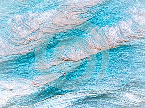 Abstract blue, gray, orange and green background - layers of rocks exposed by sea in Northumberland