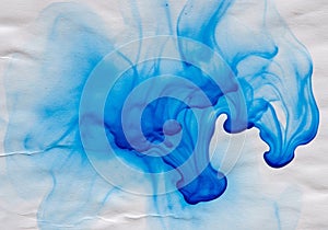 Abstract blue ink flowing over a textured white surface. The fluid