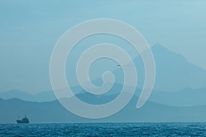 Abstract blue mountains and sea natural background with ship silhouette