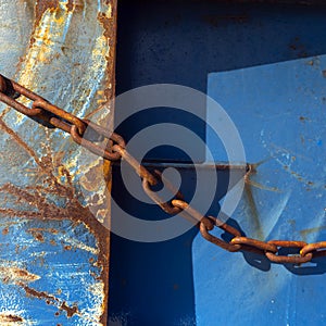 Abstract blue part of rusty sheep hull and metal chain