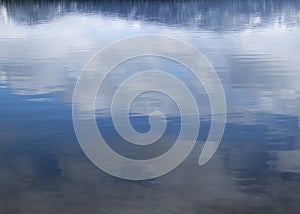 Abstract blue sky and clouds reflected in lake water