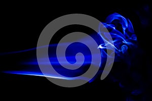 Abstract blue smoke swirls over black background