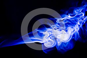 Abstract blue smoke swirls over black background