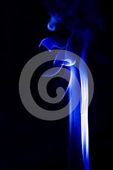 Abstract blue smoke swirls over black background