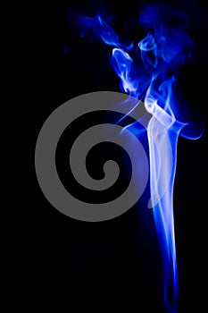 Abstract blue smoke swirls over black background