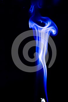 Abstract blue smoke swirls over black background