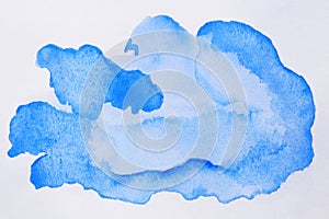 Abstract blue watercolor paint on white background, top view