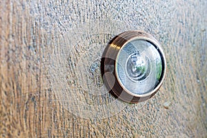 Abstract blur photo of old lens peephole on wooden door background.