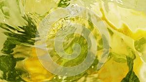Abstract blur water surface motion, splash, ripples, lemon fruit and mint leaves