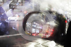 abstract blurred background of blurry raindrops on the left side mirror of a car traffic