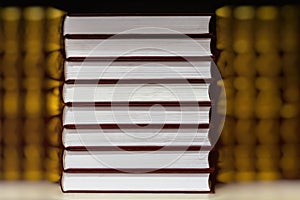 Abstract blurred background of Heap of closed books in hard covers on dark background. Education, school, study, reading