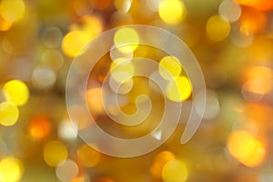 abstract blurred background - yellow, green and orange shimmering lights bokeh of amber